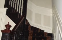 Фото темной лестницы в белом коридоре.