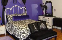 Красивый интерьер спальной комнаты с яркой фиолетовой стеной