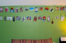 Стена в спальной комнате украшенная  картинками